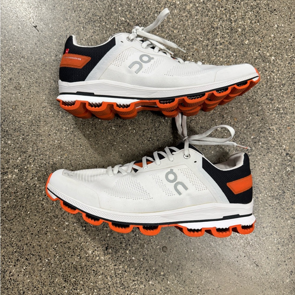 On Running White and Orange Athletic Shoes